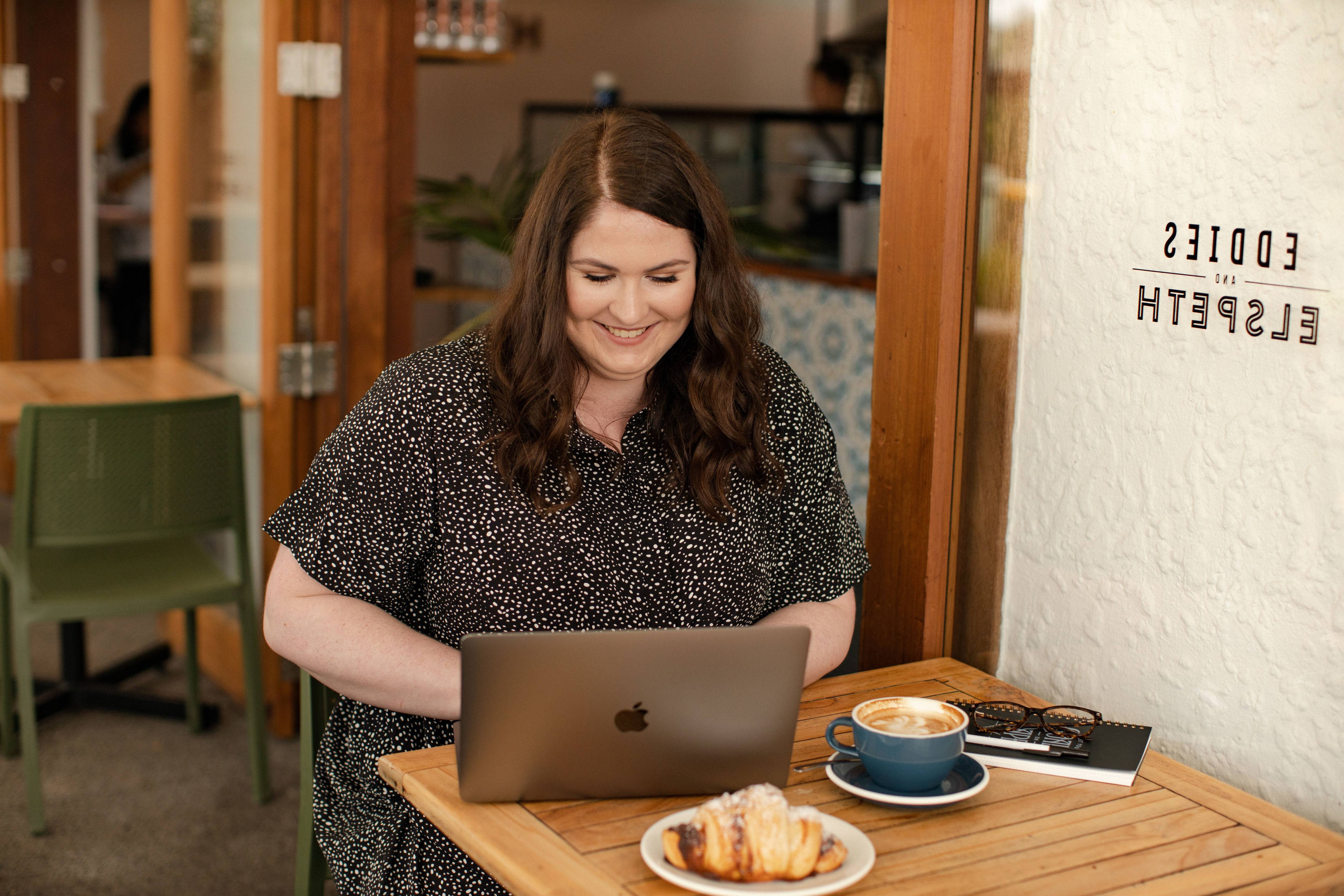 Emma sat at a laptop in a cafe