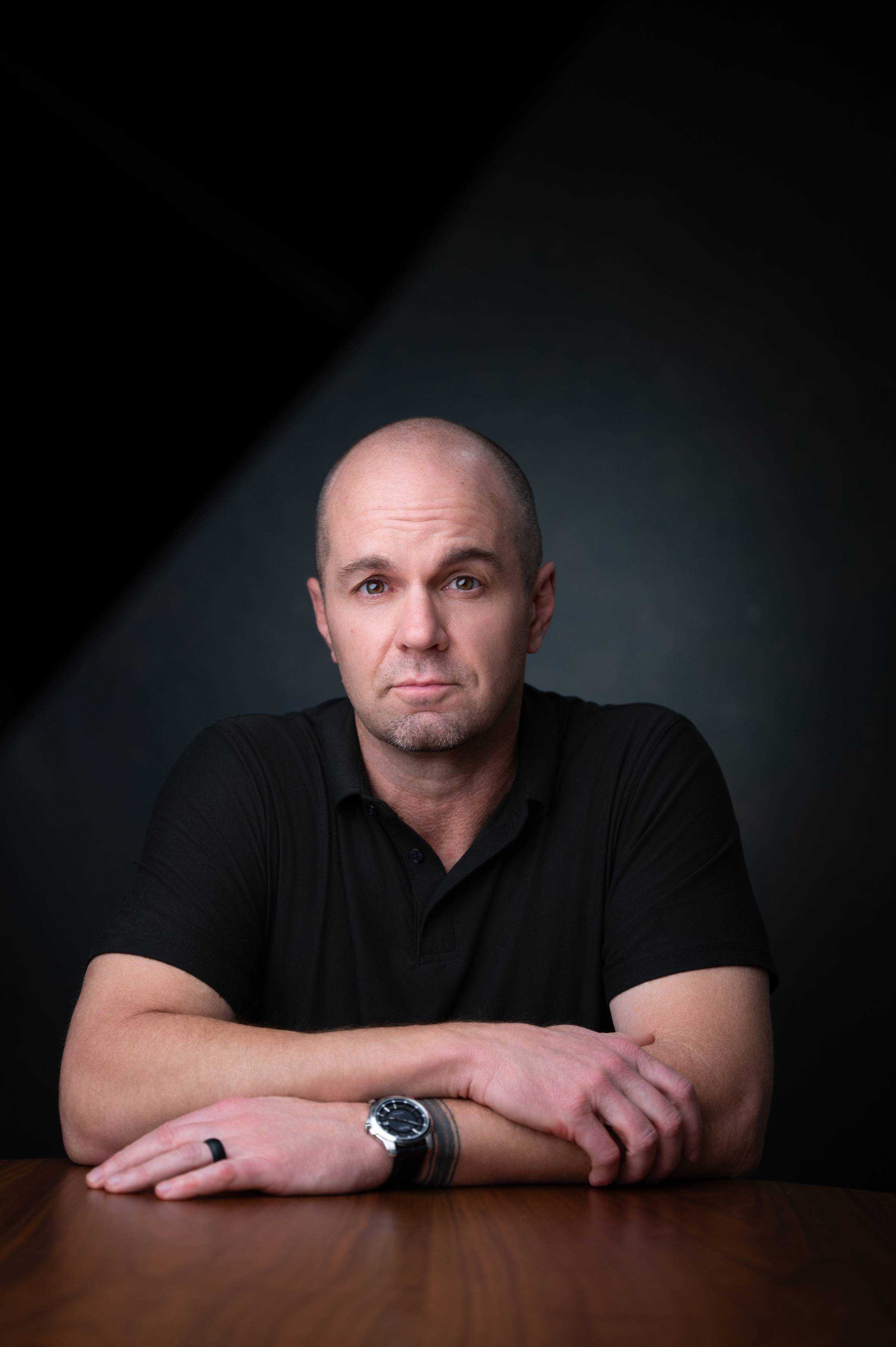 Entrepreneur Nick Berry in a boardroom with a dark backdrop. 
