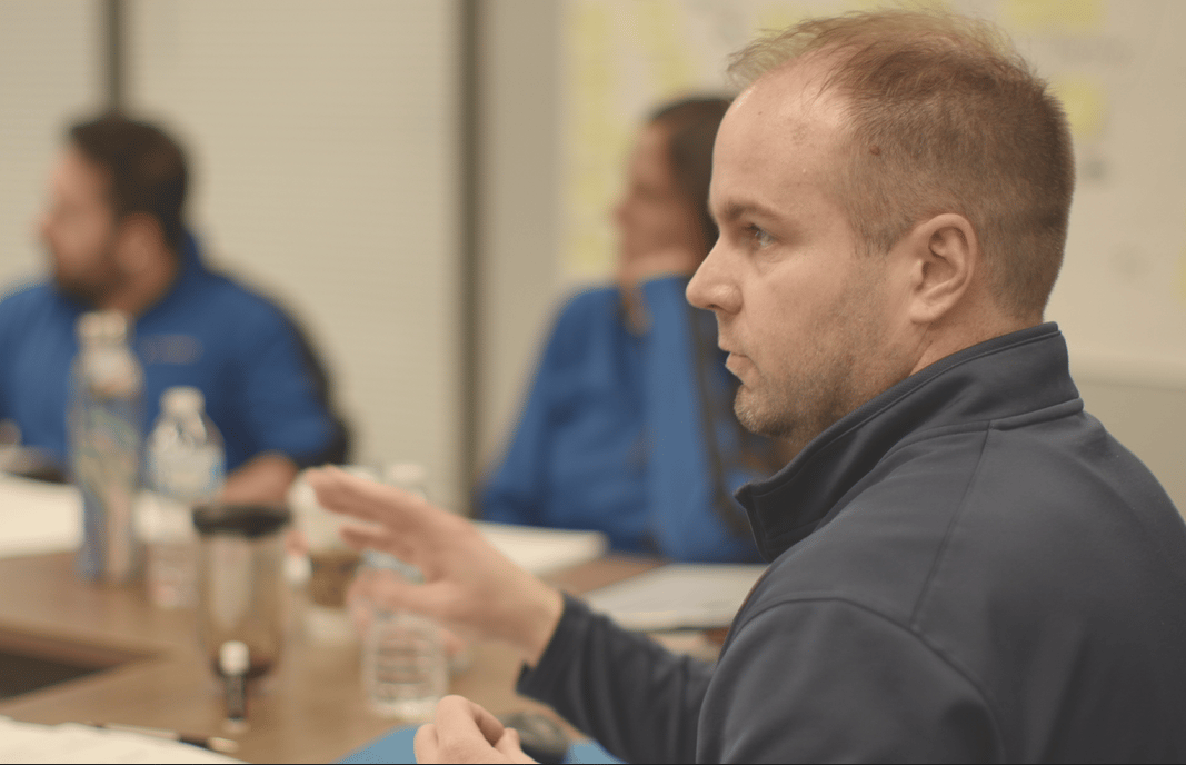 Founder speaking during a small group discussion, illustrating leadership and brand representation in AI as part of modern business decision making and due diligence.