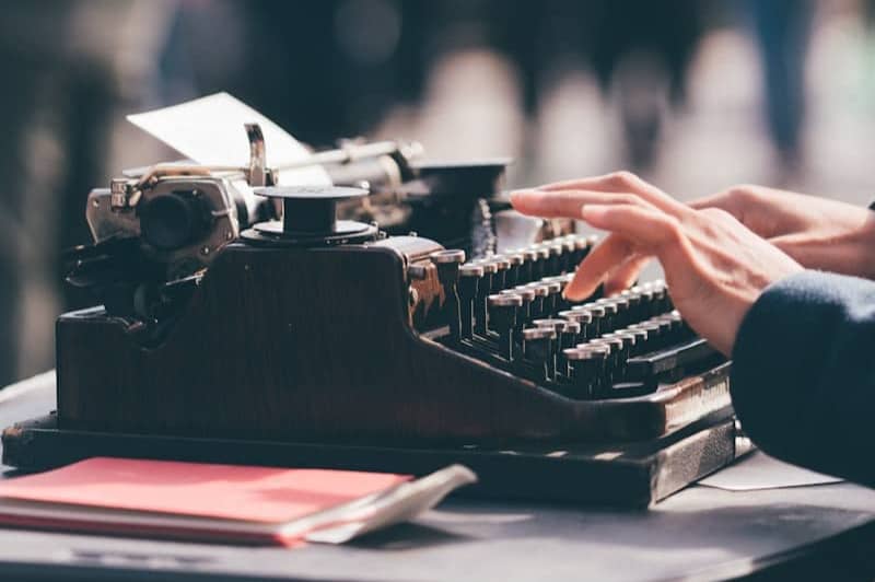 person using black typewriter