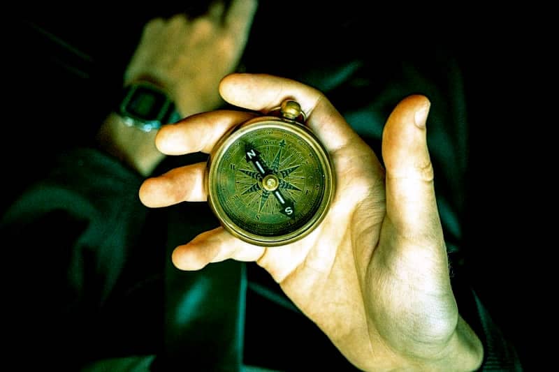 A person holding a compass in their hand