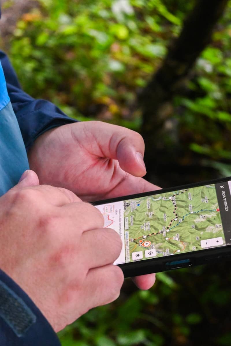 Hands holding smartphone displaying a map outdoors